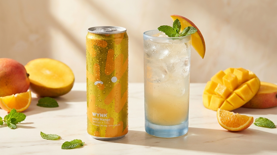 WYNK Mango THC seltzer can beside a fresh mango mocktail over ice with mint